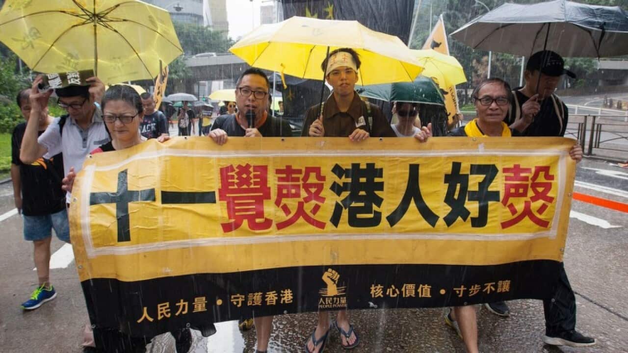 People carry a banner reading 'National Day, Hongkongers Angry Day' as they march through the streets of Hong Kong during an 'anti-authoritarian' rally on China's National Day, Hong Kong