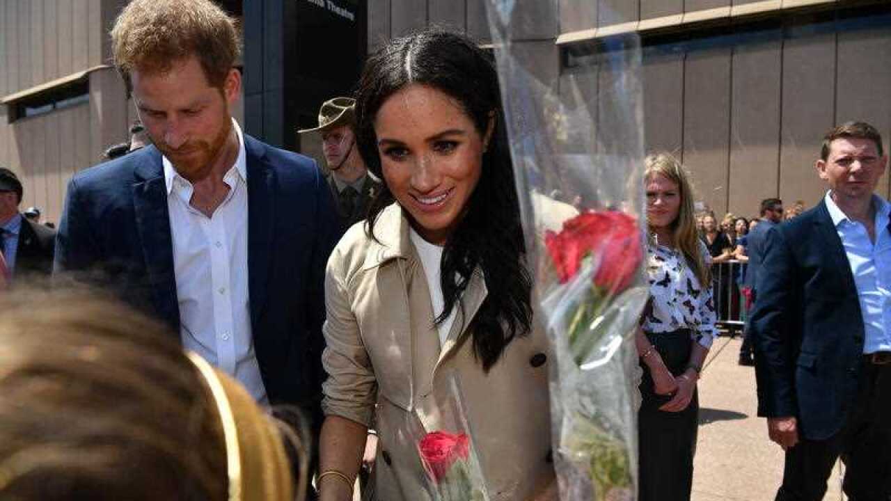 Britain's Prince Harry, the Duke of Sussex, and his wife Meghan, the Duchess of Sussex, are seen during a meet the people walk at the Sydney Opera House.