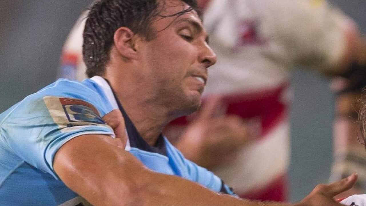 Nick Phipps tries to stop Nic Groom of the Lions.