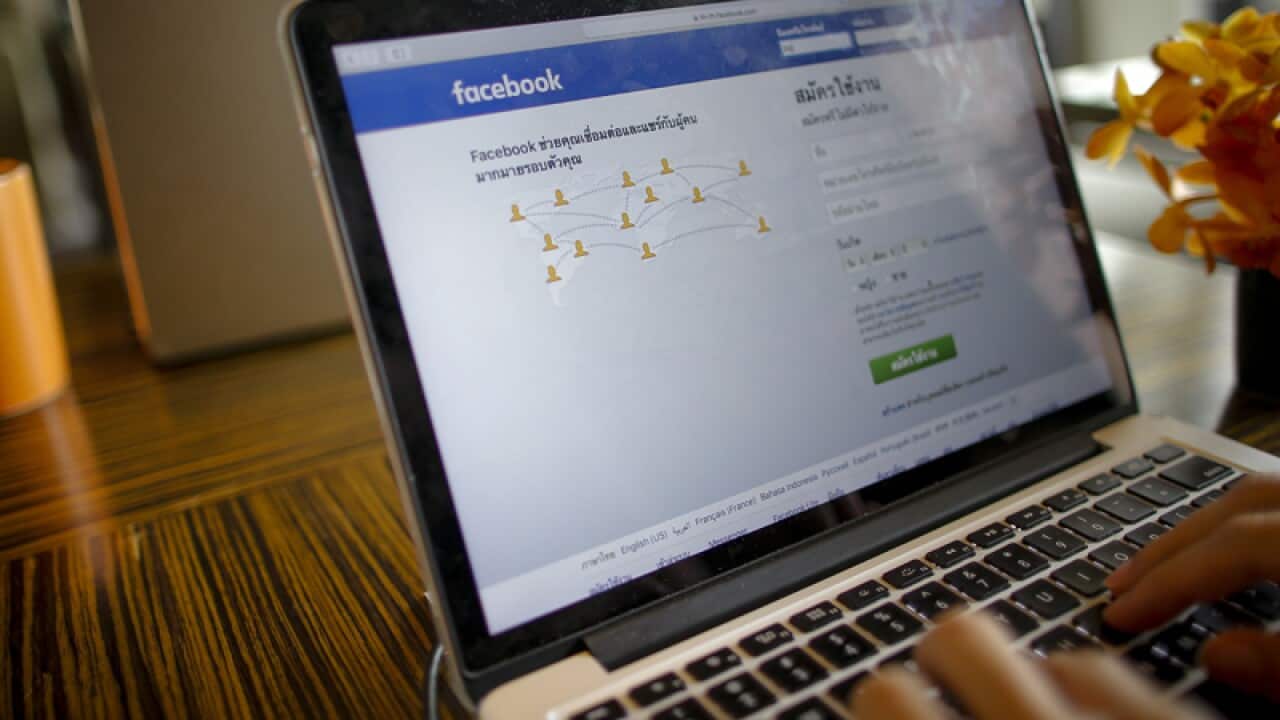 A person uses a computer displaying the Thai Facebook