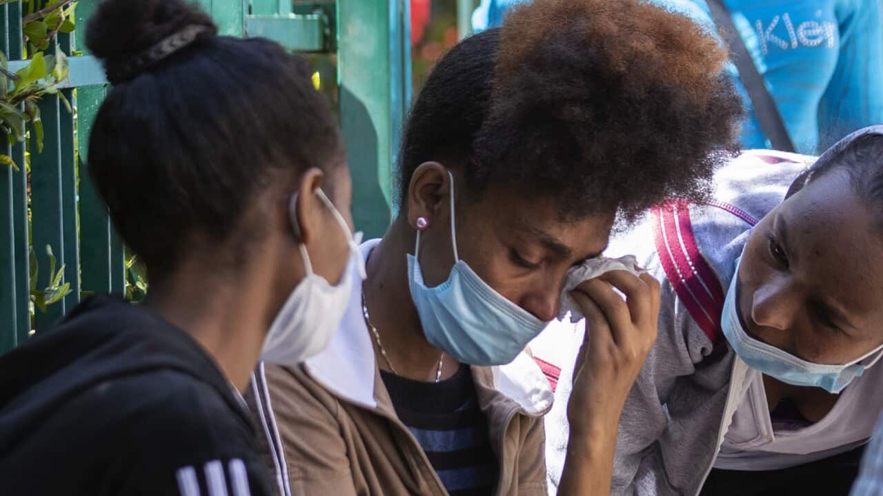 An Ethiopian domestic worker, center, cries as wait in front of the Ethiopian consulate