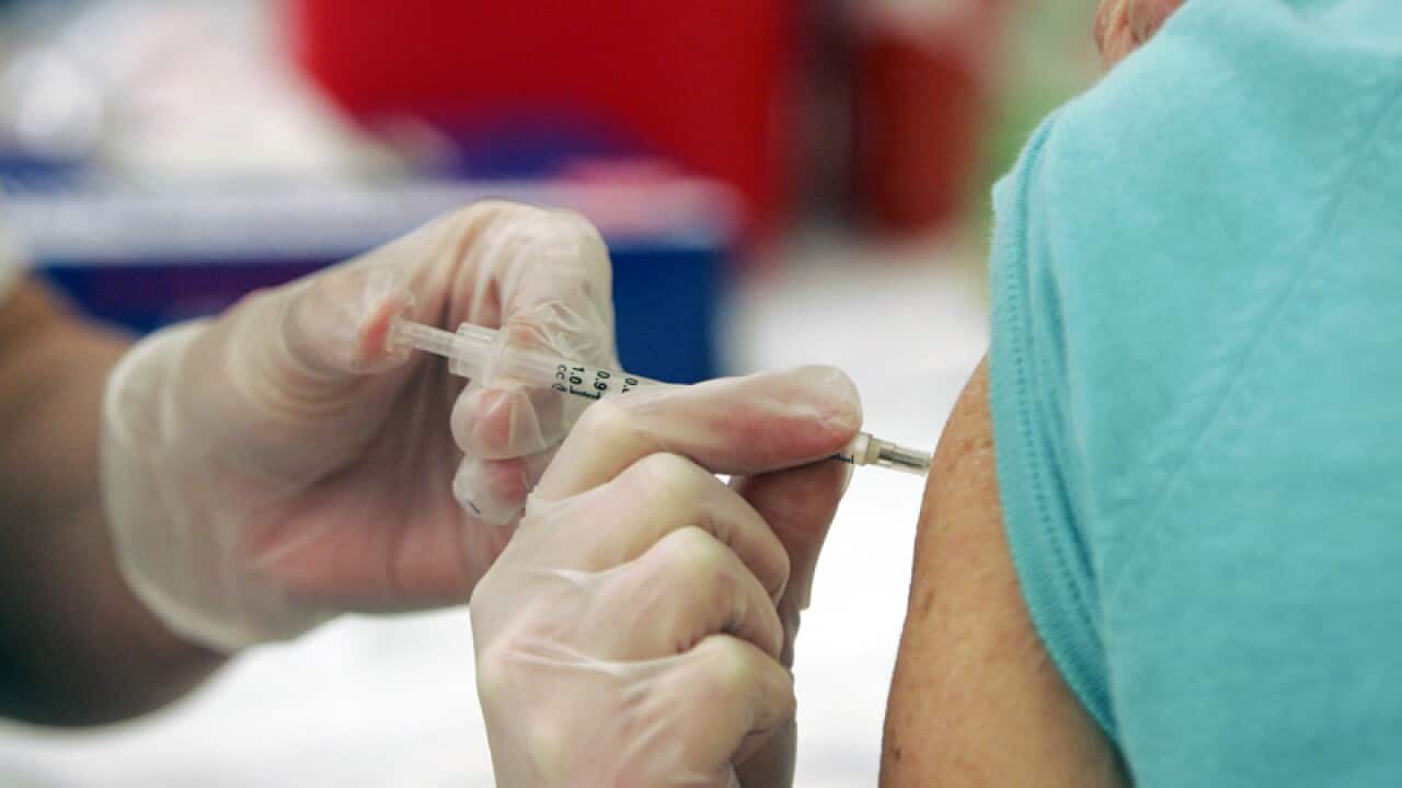 A doctor injects a costumer with the seasonal flu vaccine in Columbia