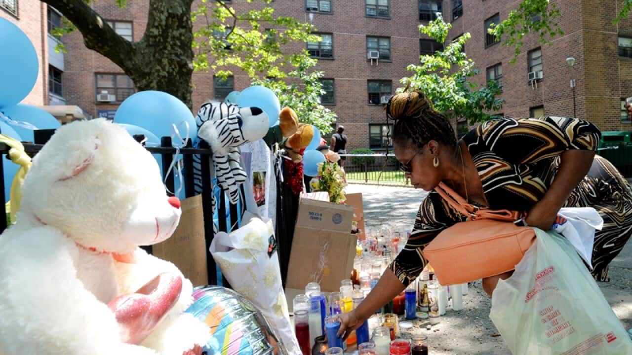 Mourners place candles at a memorial for a child stabbing victim