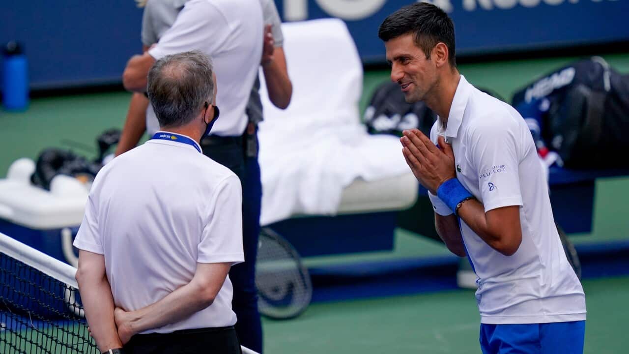 Novak Djokovic talks with the umpire after inadvertently hitting a line judge with a ball during the match against Pablo Carreno Busta at the 2020 US Open tennis championships