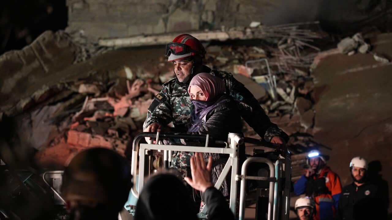 A woman who survived an Israeli airstrike is rescued by a firefighter from a destroyed building in central Beirut, Lebanon.