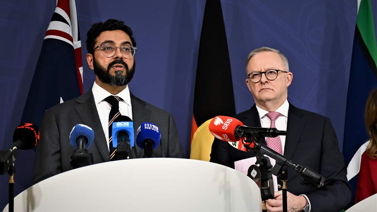 Aftab Malik and Anthony Albanese stand at a lectern surrounded by microphones