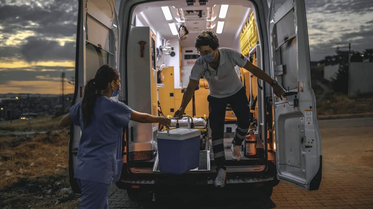 Medical team in a hurry carrying organ transplants box by ambulance during pandemic