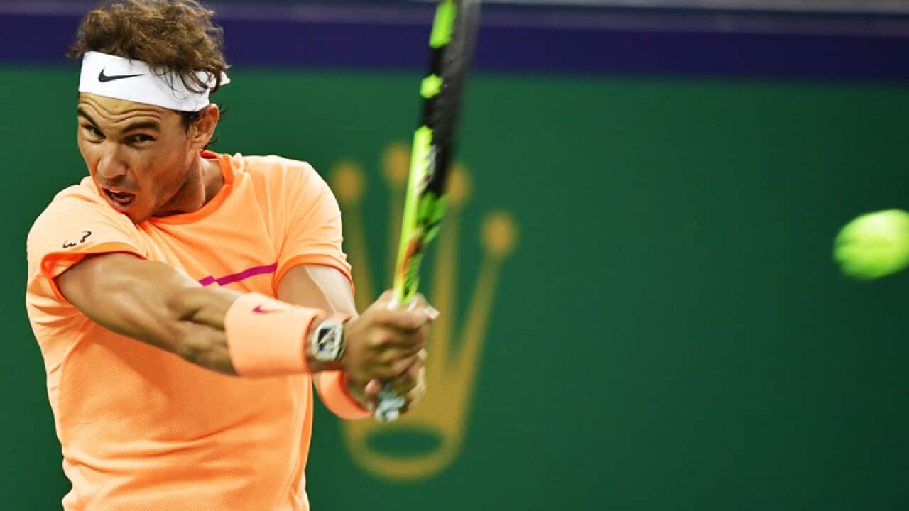 Rafael Nadal of Spain returns a shot to Viktor Troicki of Serbia