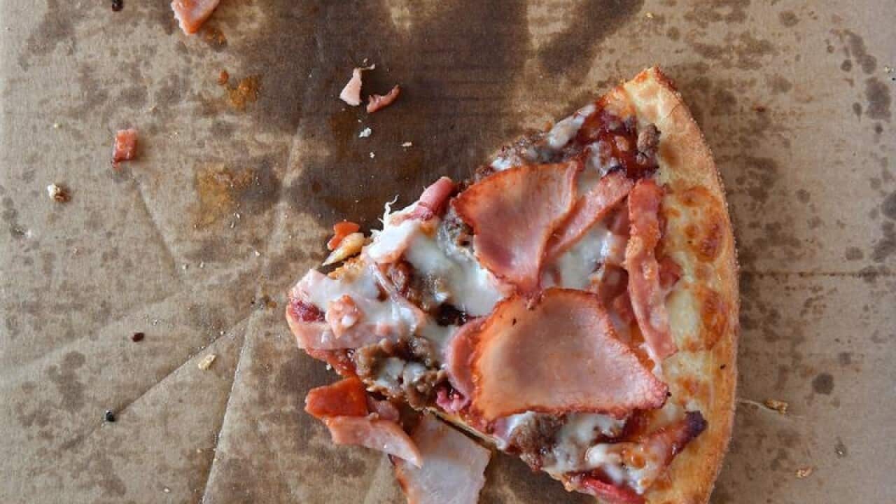 A single slice of a Domino's BBQ meatlovers pizza