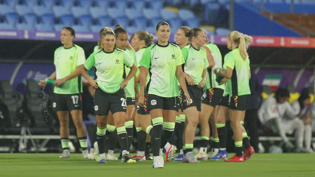 A group of women wearing green football jerseys on a pitch.