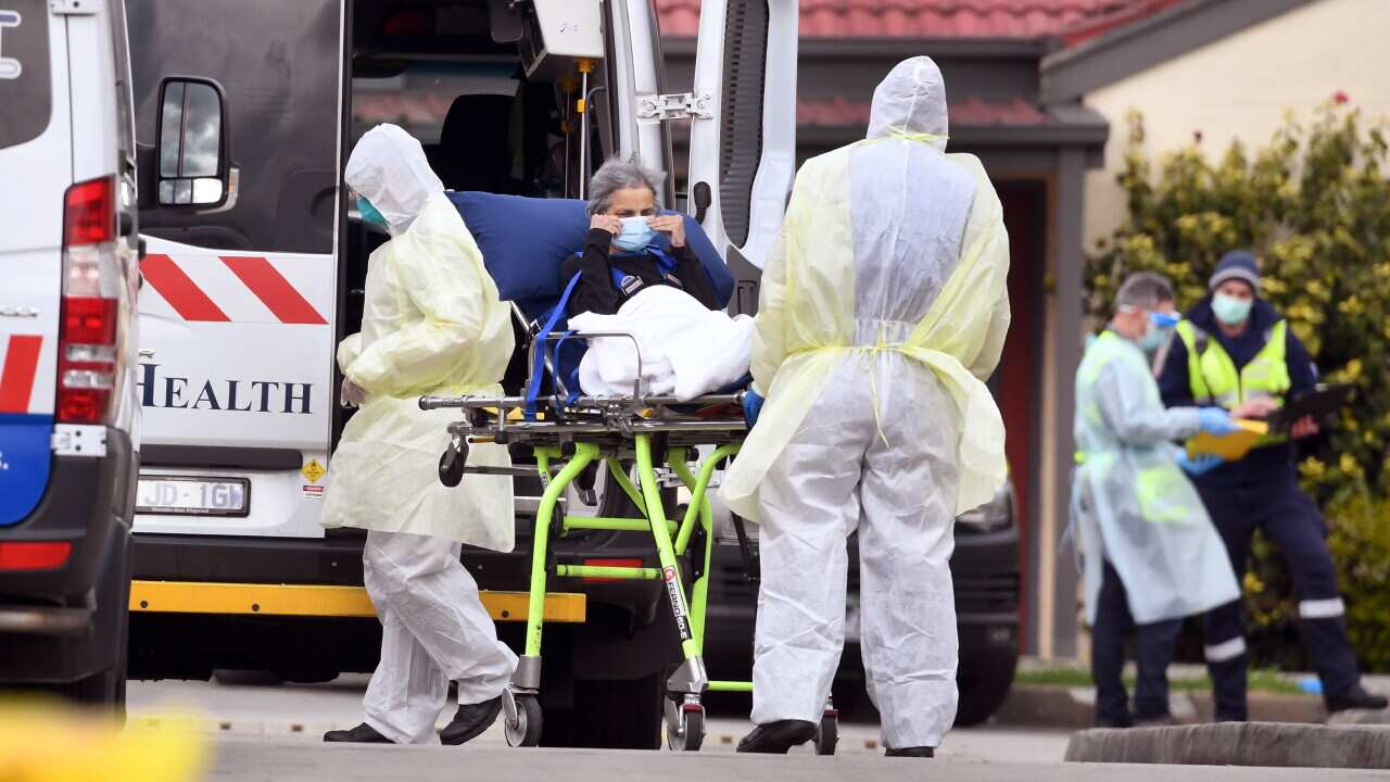 Ambulance officers remove a resident from the St Basil's Home for the Aged in the Melbourne suburb of Fawkner