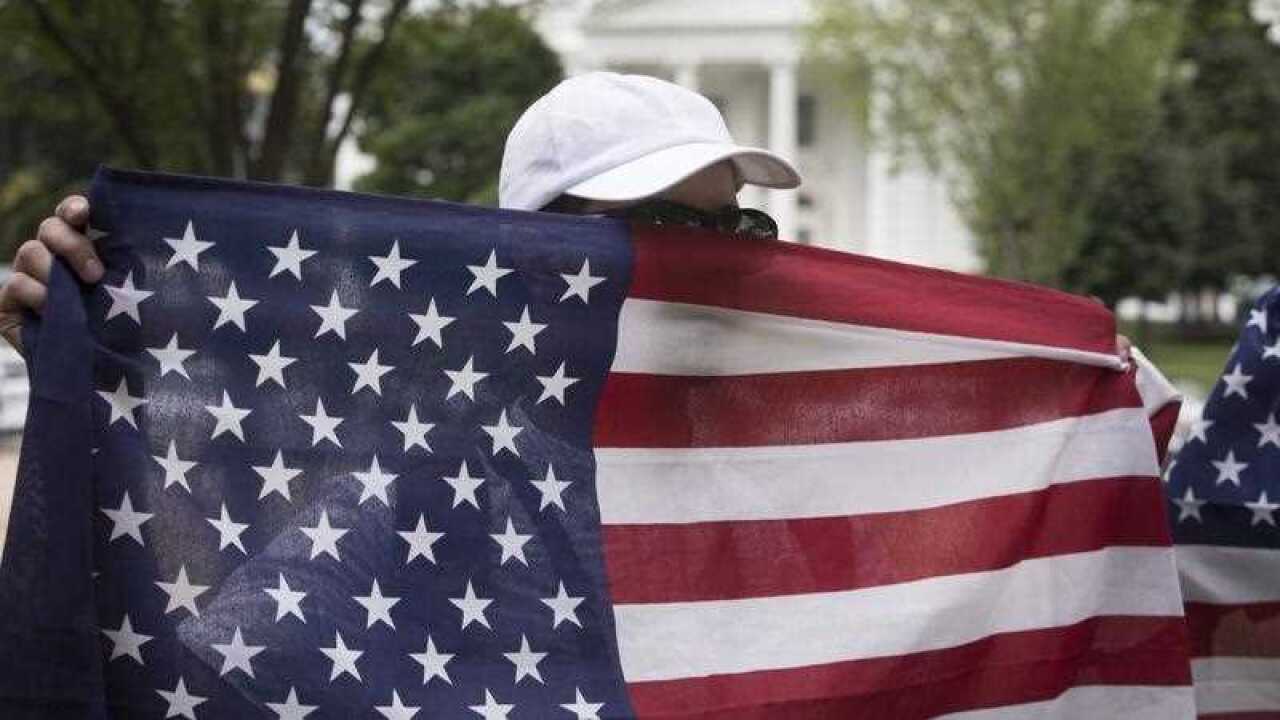A white supremacist holds a US national flag over his face at Lafayette Park across the street from the White House.