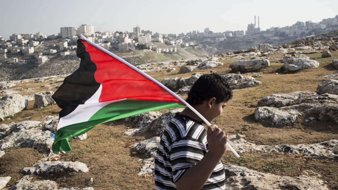 A Palestinian child holds his national flag as Palestinians erect tents in the E1 area to protest President Obama's visit to the Middle East. (Getty)