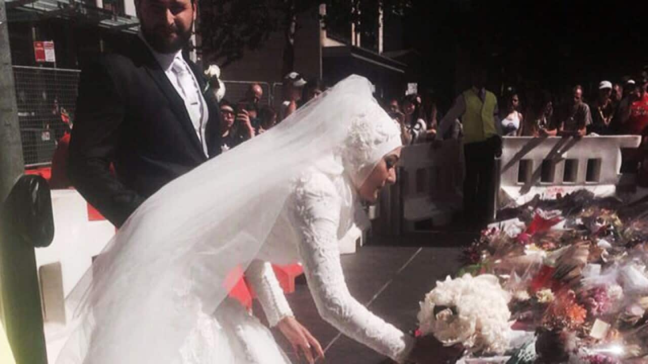 Australian Muslim bride Manal Kassem placing her bridal bouquet at the Martin Place Memorial. (AAP)