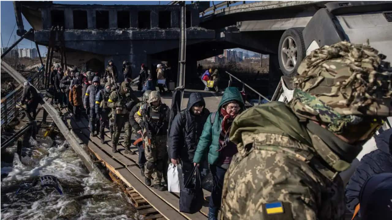 Residents of Irpin and Bucha, in the Kyiv region, flee fighting via a destroyed bridge on 10 March 10, 2022.