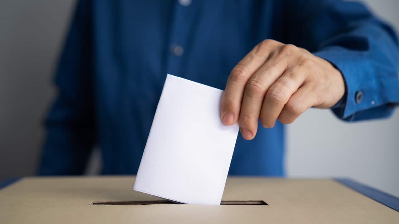 A man puts his ballot in a box