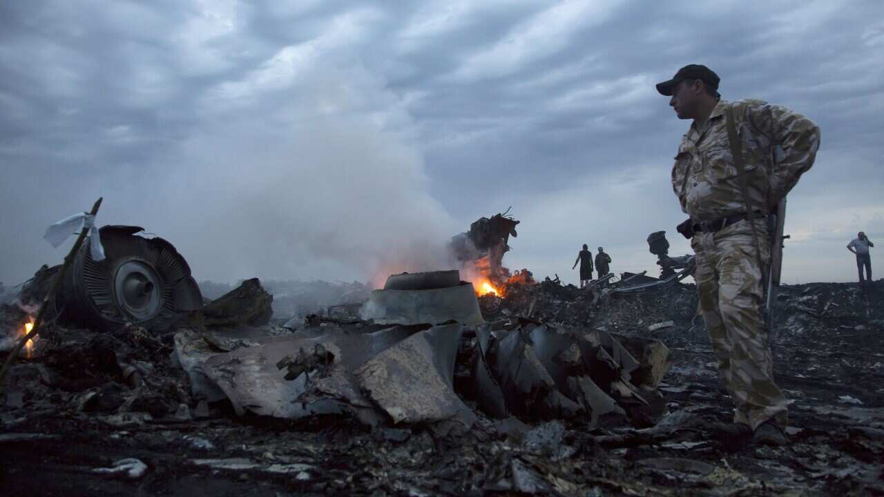 People stand in a field of plane crash