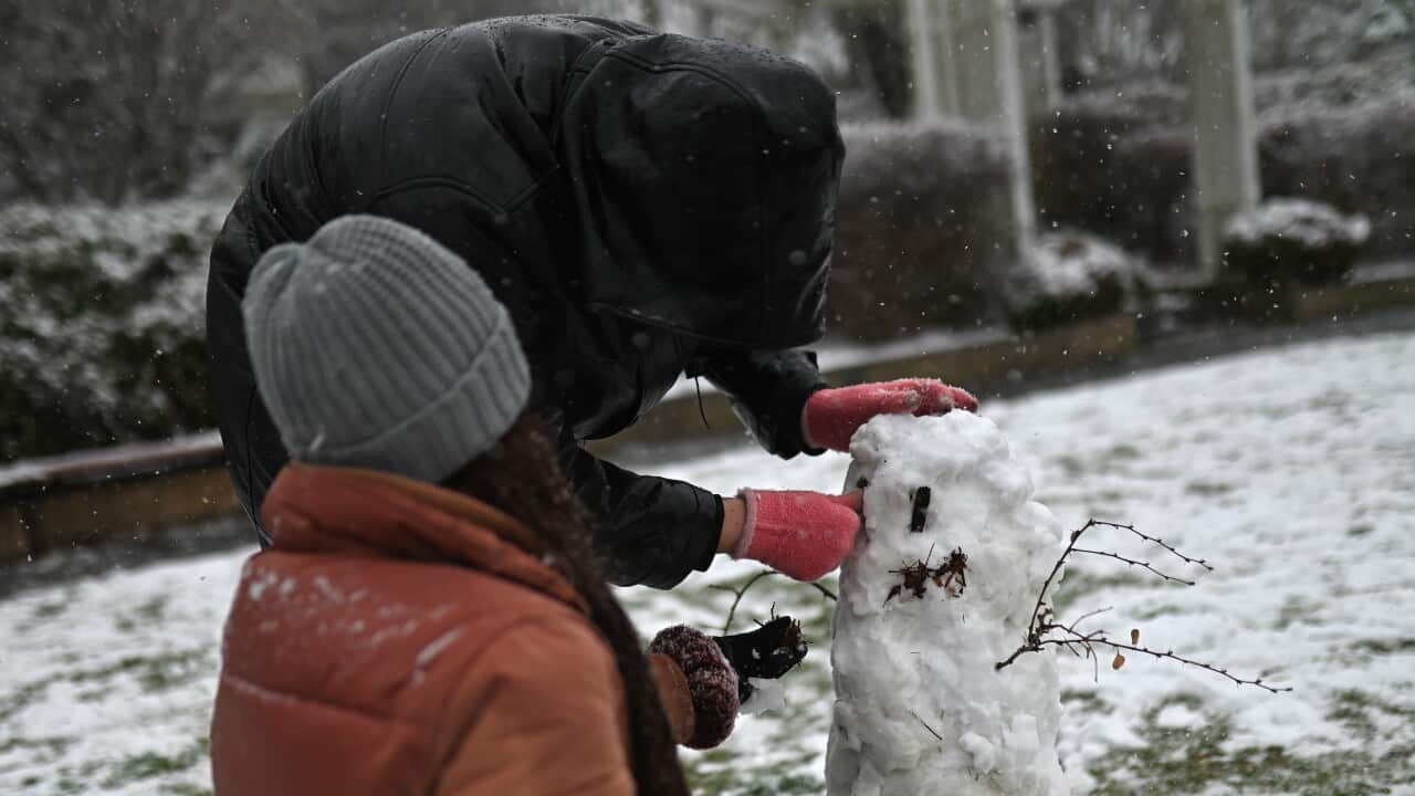People build a snowman during snowfall in Katoomba, NSW, Thursday, June 10, 2021. (AAP Image/Steven Saphore) NO ARCHIVING