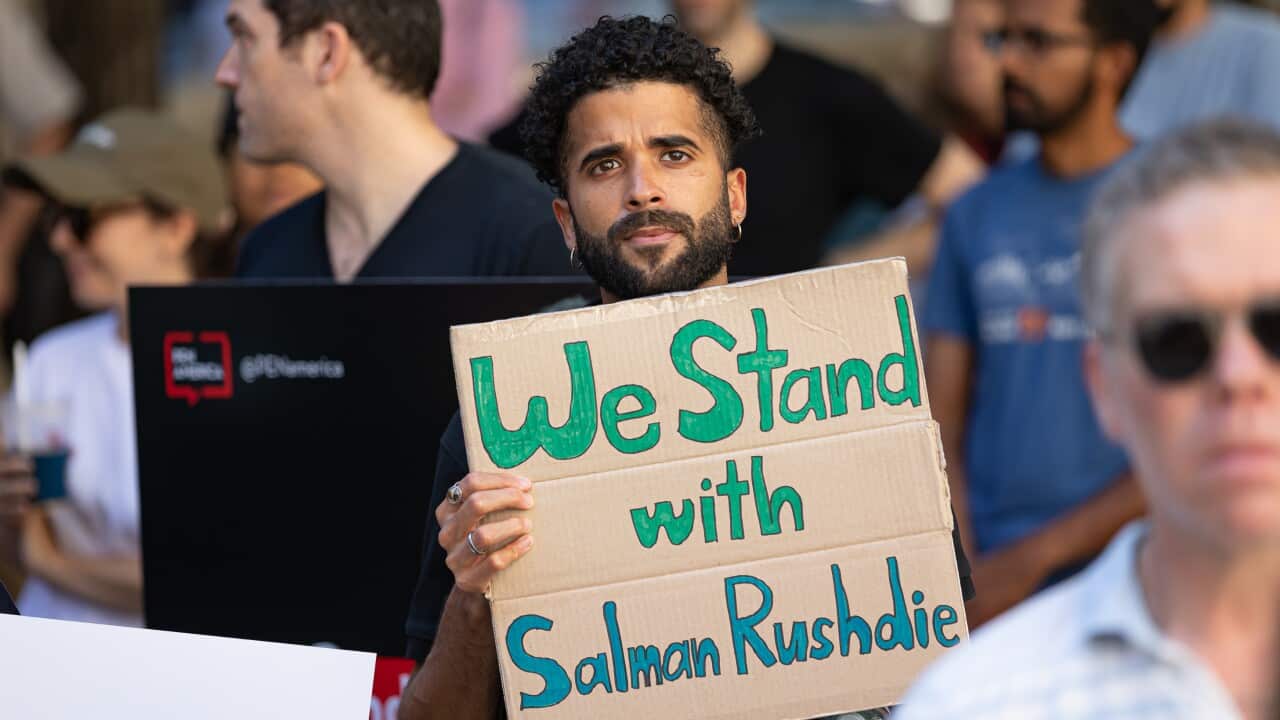 A man holds a sign in solidarity with Salman Rushdie at the ;Stand With Salman' event at the New York Public Library.