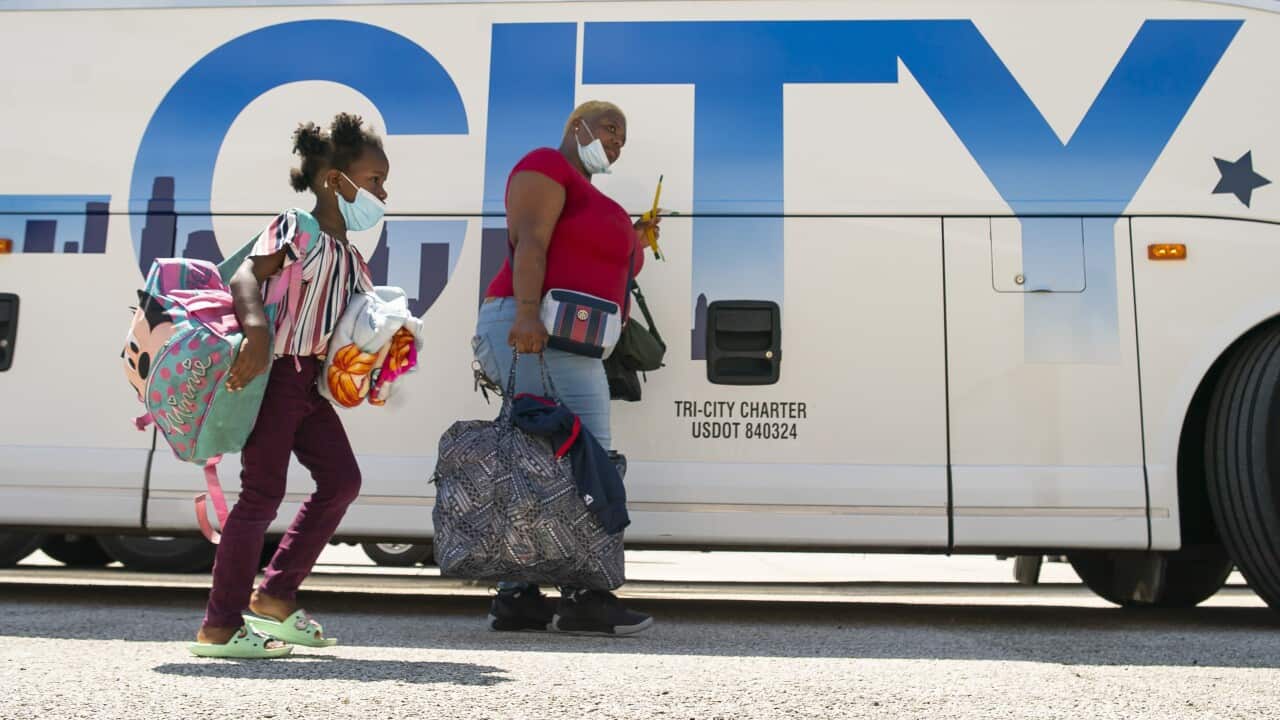 Alfreda Henderson and her daughter, Miracle, 5, walk to a charter bus that will evacuate them from Galveston Island to Austin (AAP)
