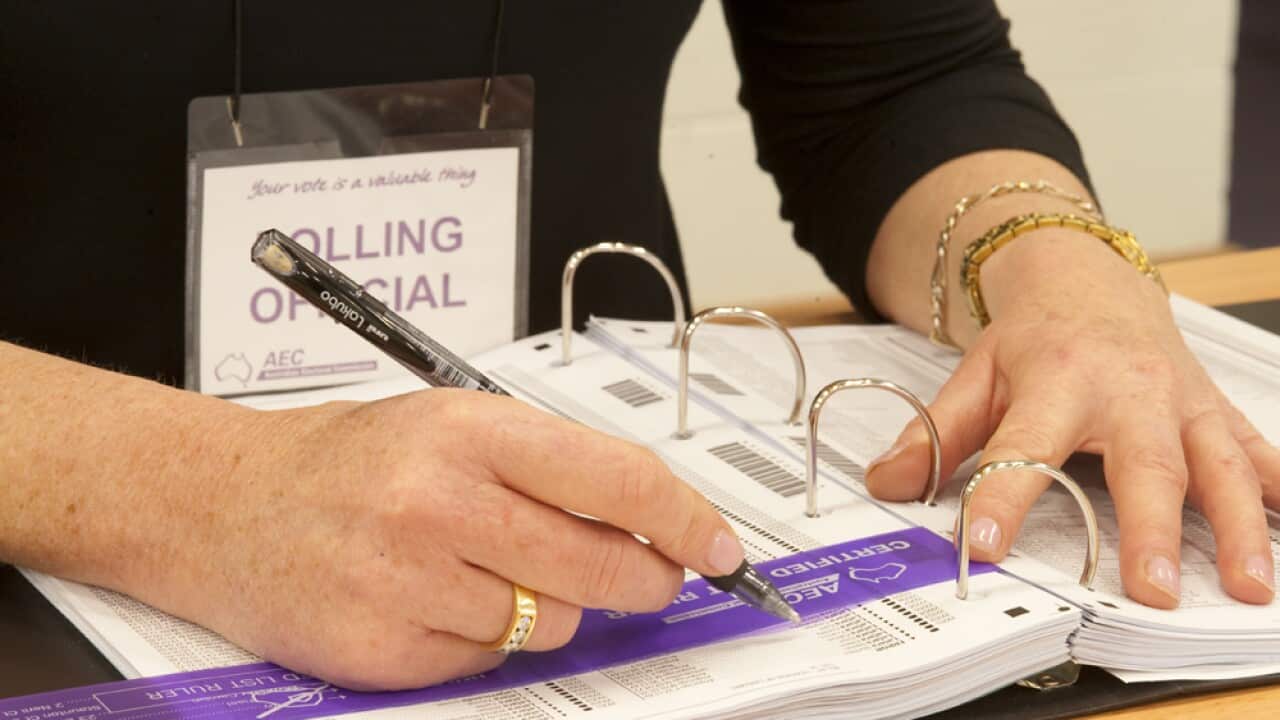Polling officer marks off a voter (SBS)