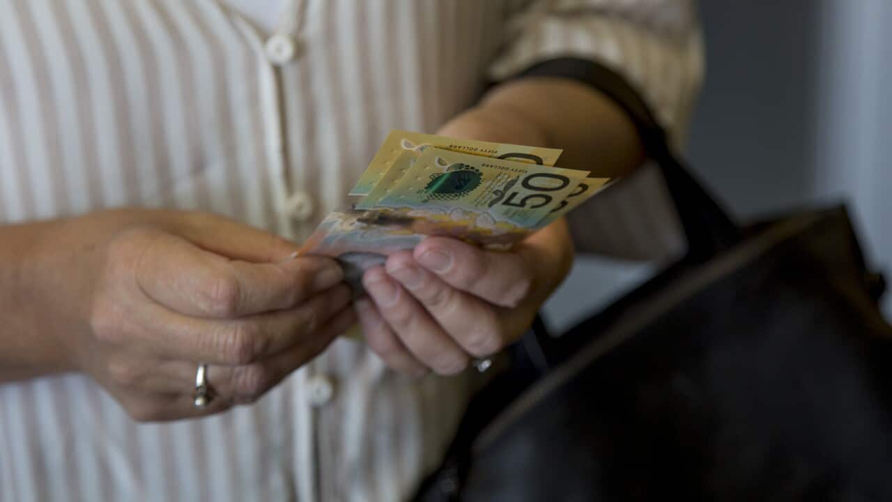 A lady holding Australian currency