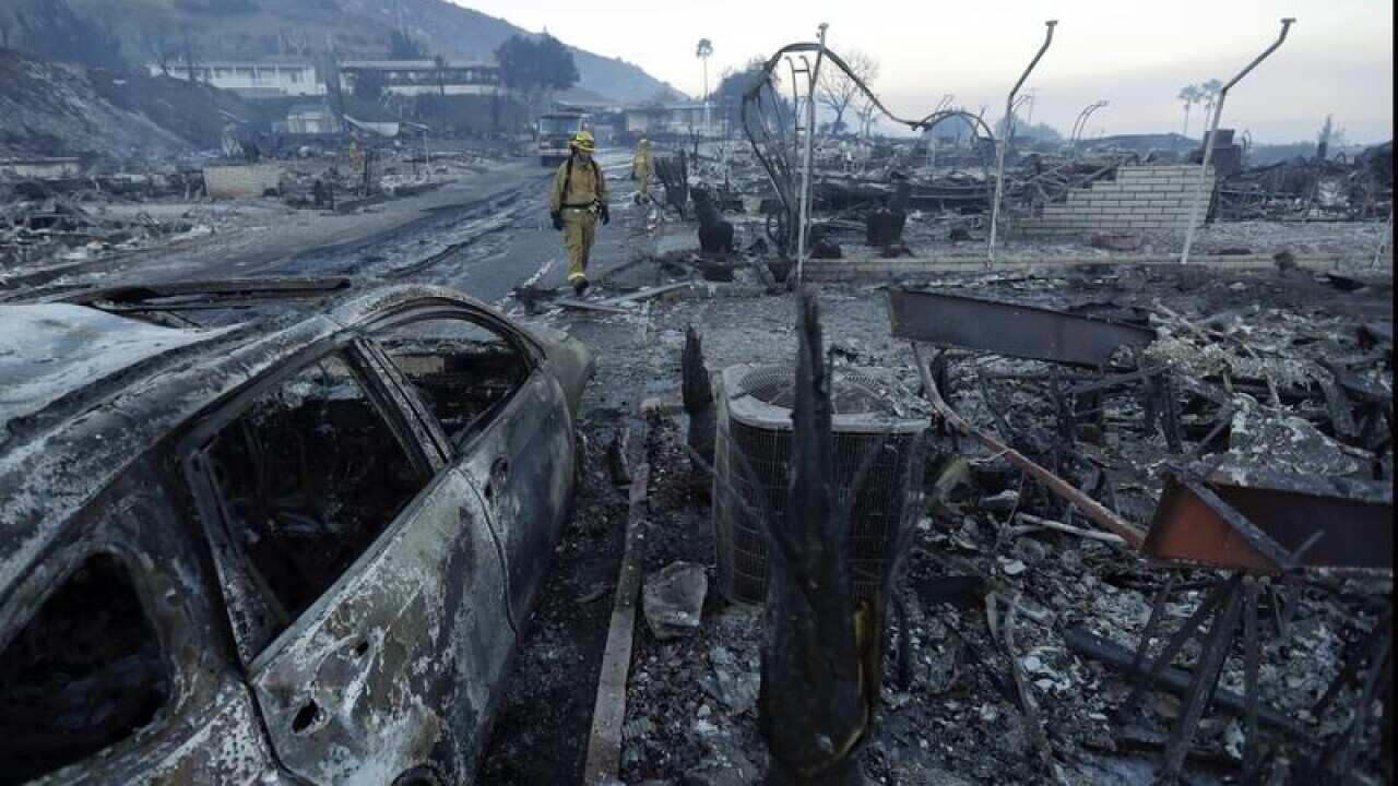 Fire crews search homes destroyed in the Rancho Monserate Country Club community, California.