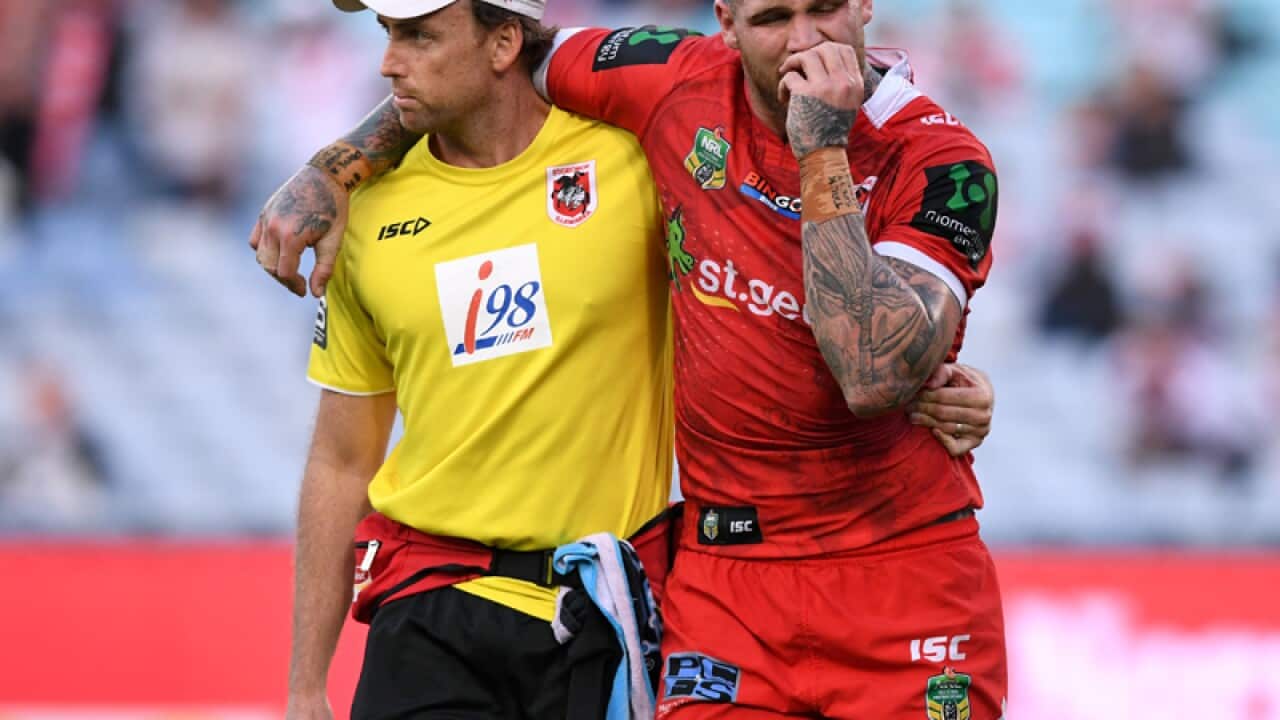 Josh Dugan of the Dragons (R) is treated by medical staff