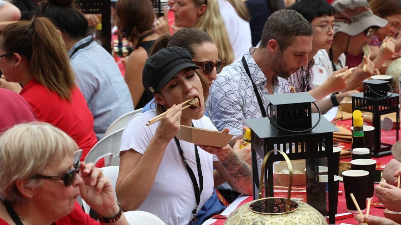 Pip Bradley from Bronte (centre, white shirt black hat) eats dumplings at Jonsey & Amanda's Sydney Lunar Festival World Record Yum Cha event, Darling Harbour, 5th February 2019.Photo by Damian Shaw / City of Sydney