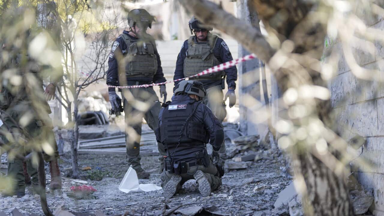 Three members of the Israeli police bomb squad work at the site of the explosion.