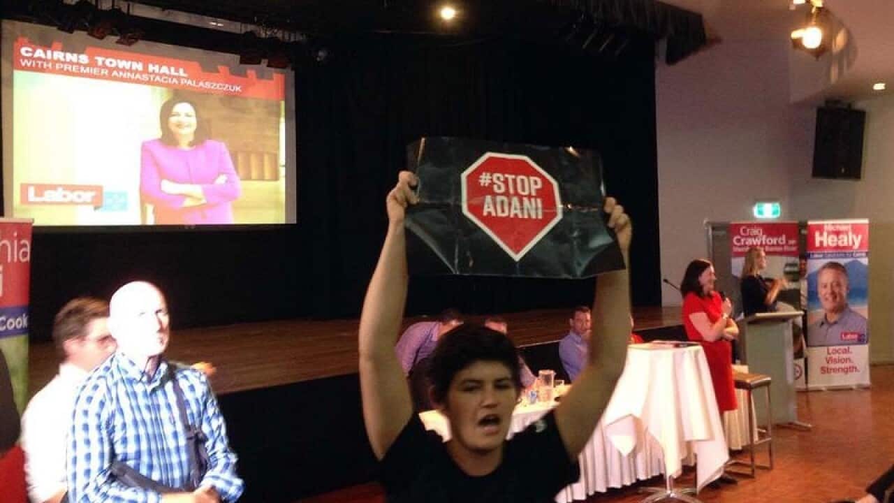 A protester disrupts a meeting held by the Queensland premier