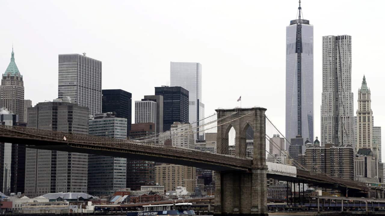 A ferry boat passes Brooklyn Bridge in New York
