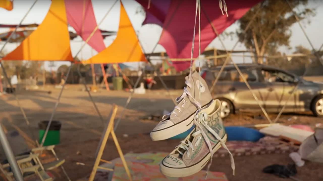 A camp site. A pair of sneakers are hanging.