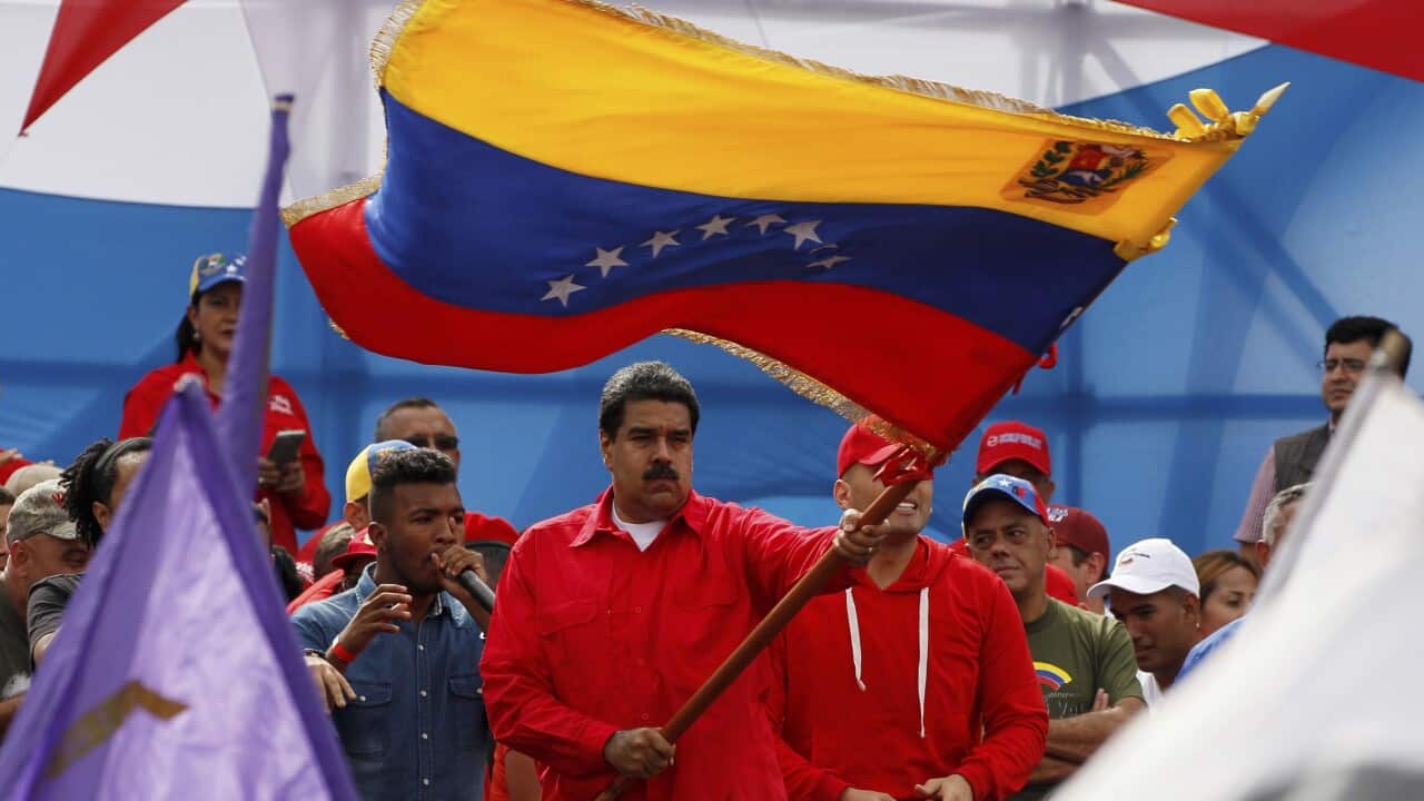 Venezuela's President Nicolas Maduro waves a national flag during a rally in Caracas.