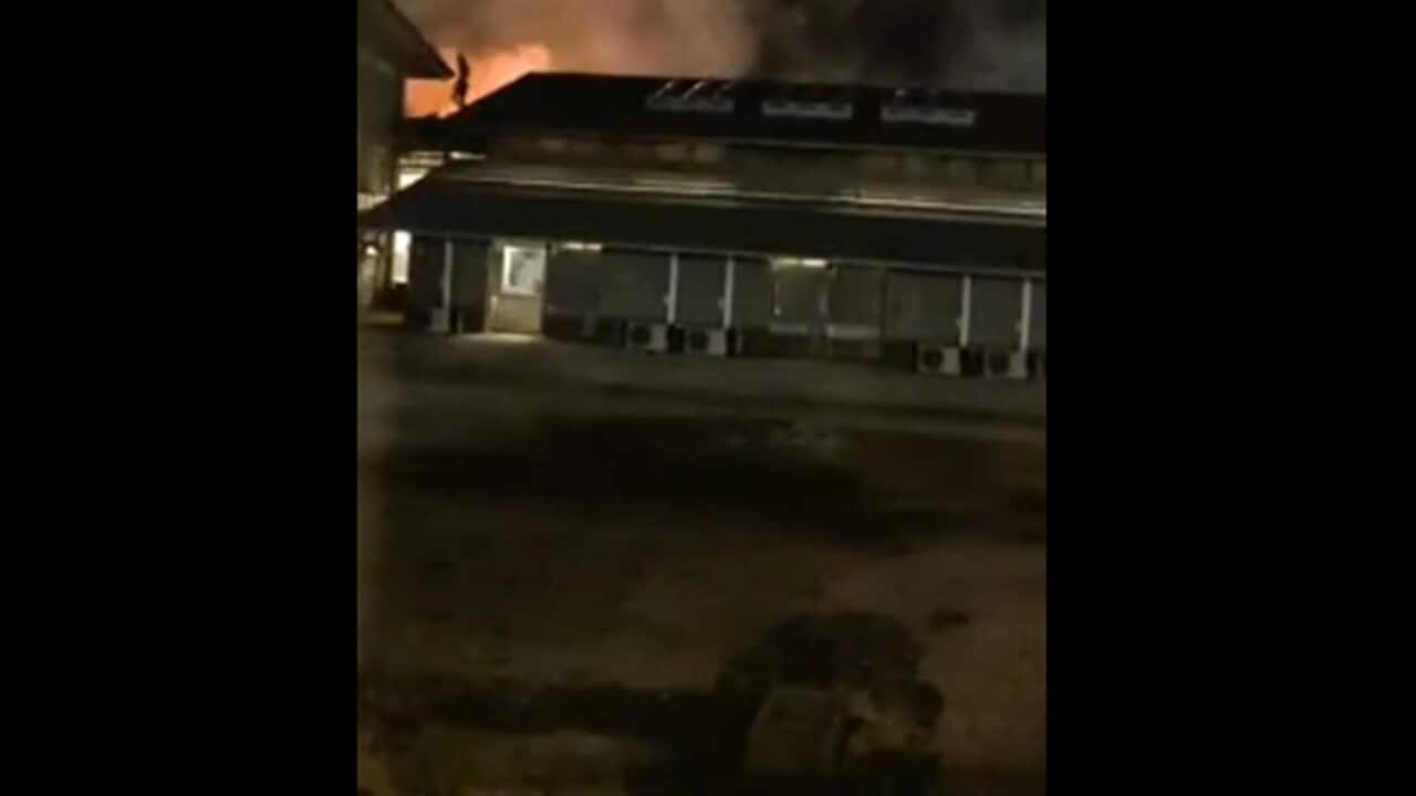 Video on social media shows a building on fire at Christmas Island Detention Centre, and a detainee on the roof.