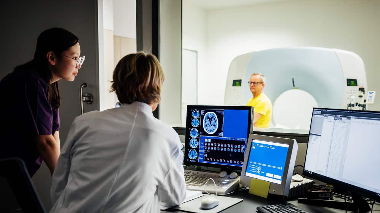 Female Doctor And Nurse Looking At Patient Data Of A CT-Scan