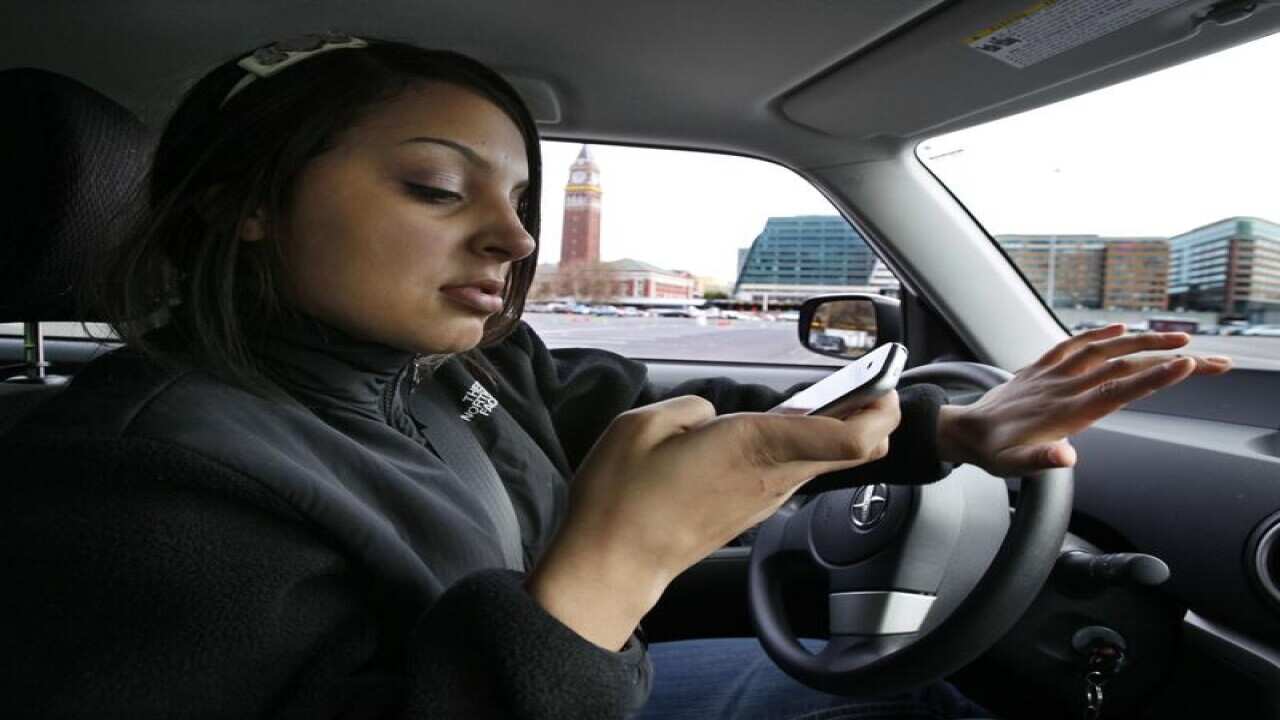 New driver Brandi Eadie, 16, looks down at her mobile phone.