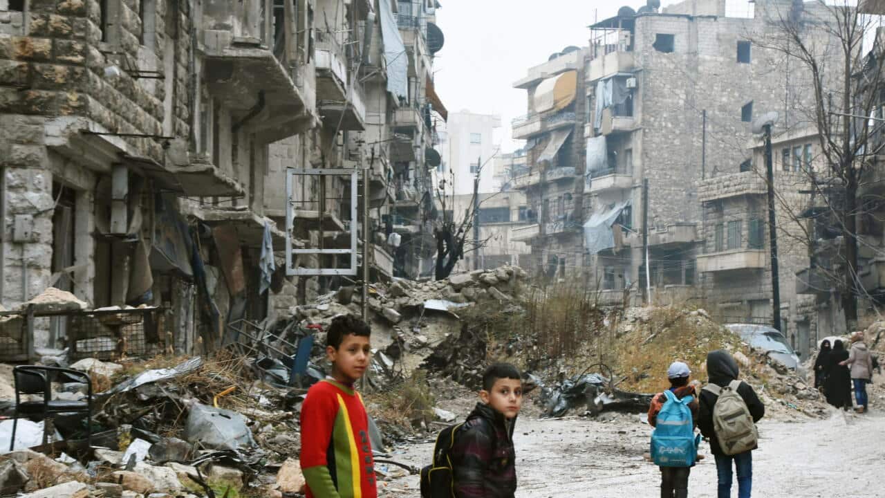 Children walk in a devastated area