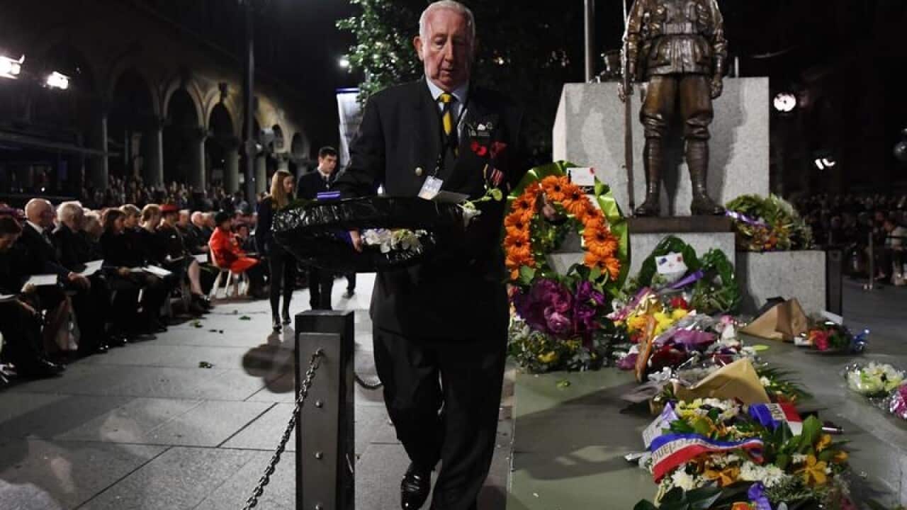 An attendant with floral wreaths at the Martin Place dawn service.