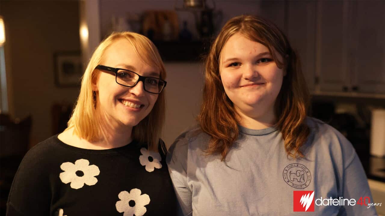 A woman with medium-length blonde hair, reading glasses, and a black jumper with a floral print stands beside an overweight teenage girl in a grey t-shirt.