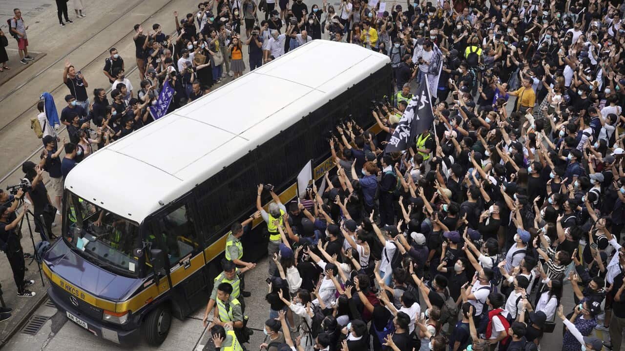 Supporters surround a police bus carrying political activist Edward Leung.