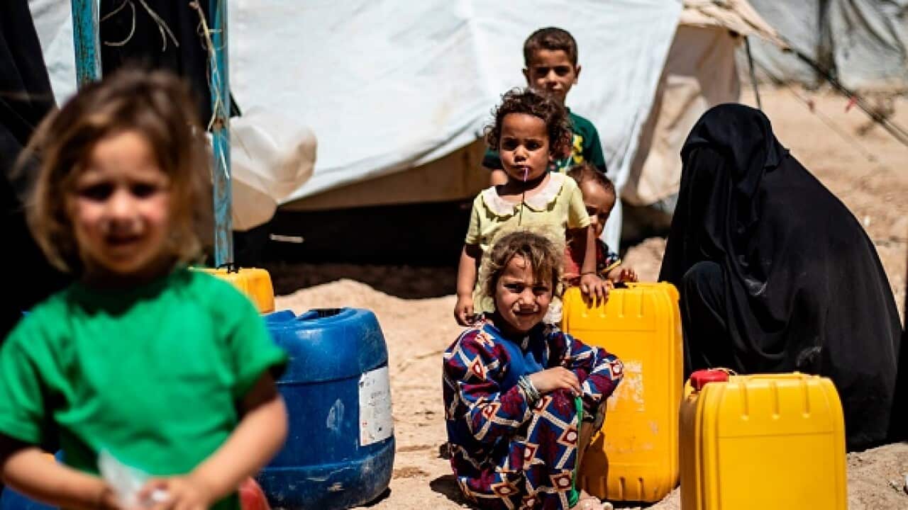 Displaced Syrians queue for water inside al-Hol camp for displaced people in northeastern Syria.