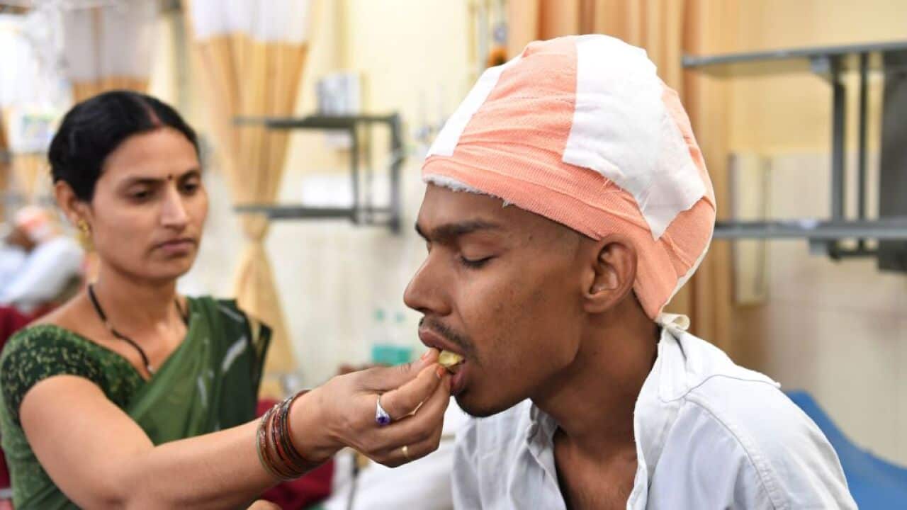 Santlal Pal, 31, rests in his bed as his wife Manju, feeds him a slice of apple at the BYL Nair hospital in Mumbai on February 22, 2018.
