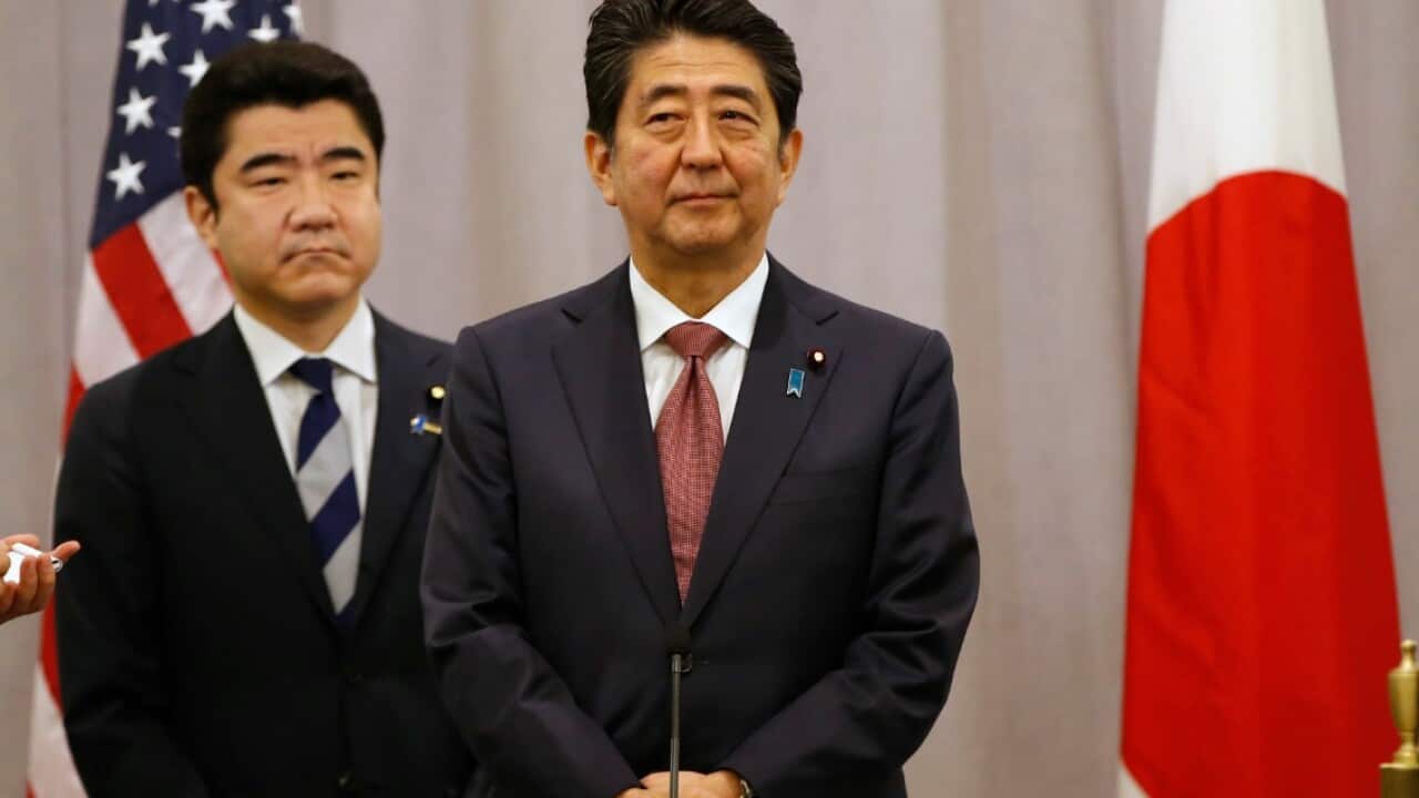 Japanese Prime Minister Shinzo Abe, right, listens to questions from members of the press after meeting with President-elect Donald Trump, 