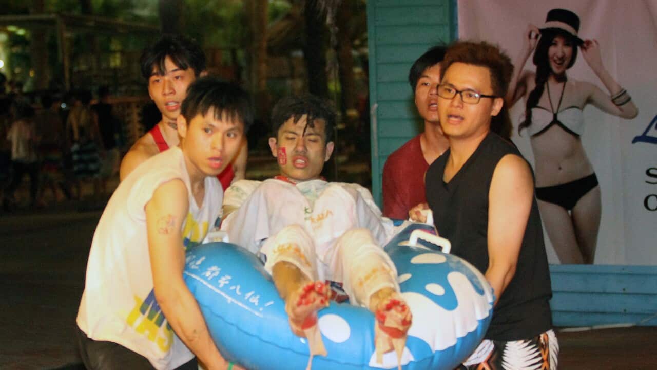 People carry an injured man at the Formosa Fun Coast amusement park after an explosion in the Pali district of New Taipei City on June 27, 2015. (AFP PHOTO / STR)