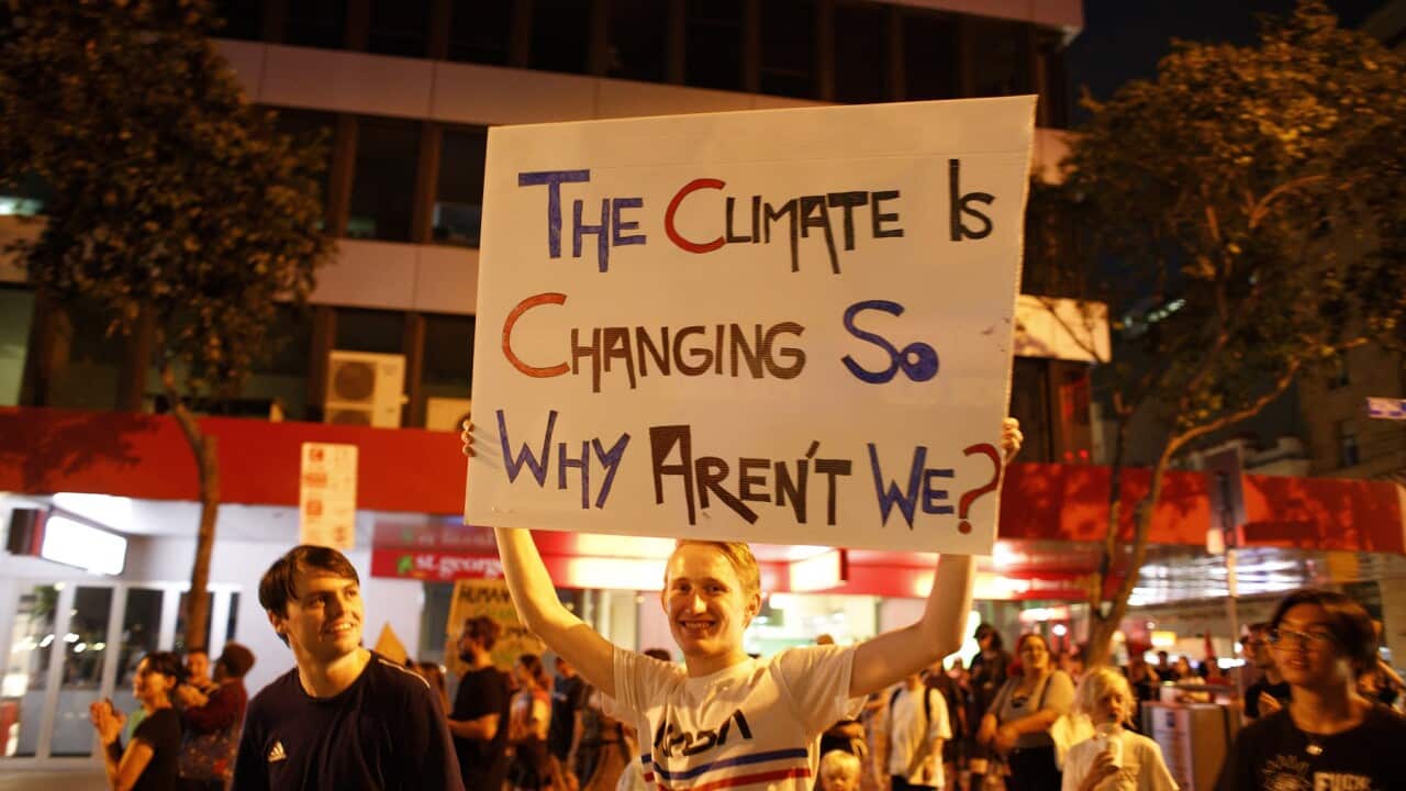 A protester holds a placard at a Uni Students For Climate Justice rally in Brisbane in 2020
