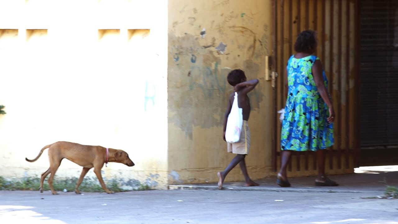 A child carries supplies from a grocery store in the north Queensland Aboriginal community in Kowanyama today.