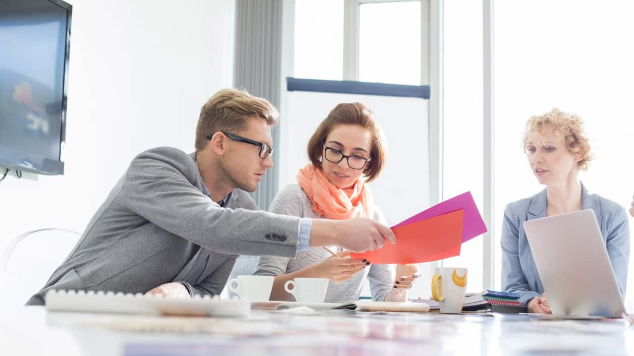 Creative businesspeople analyzing documents at desk in office