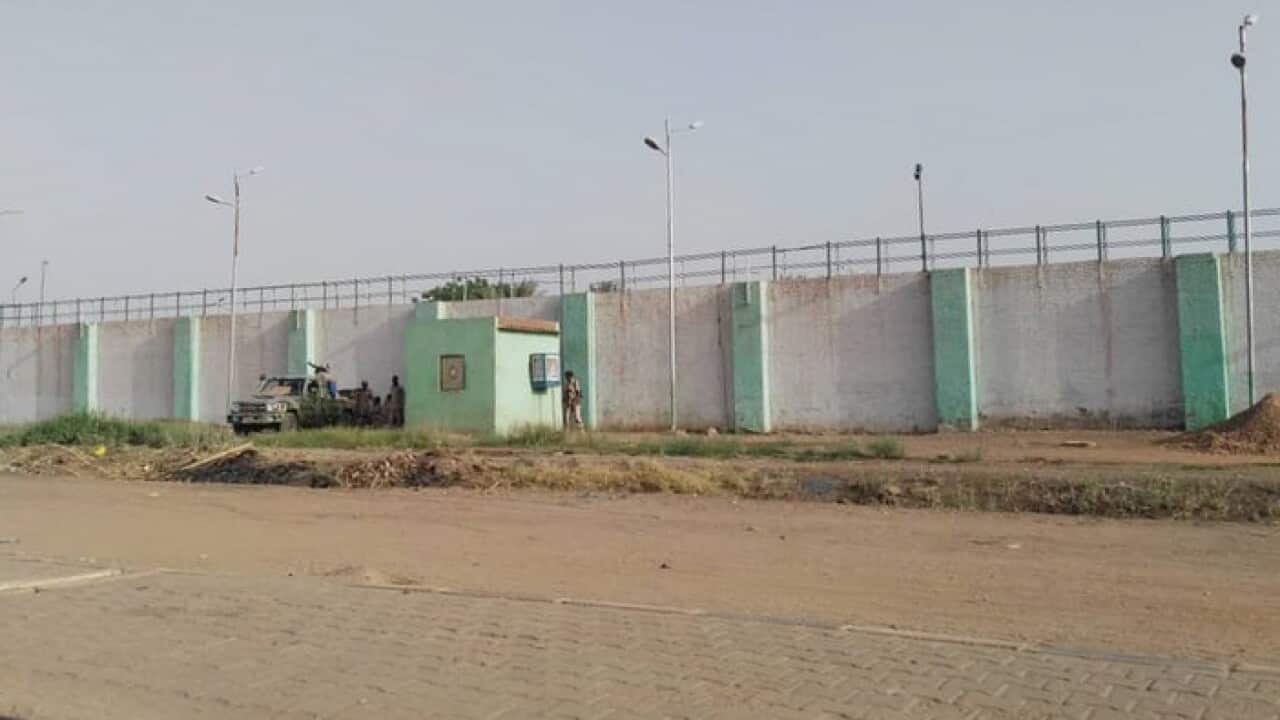 Sudanese soldiers stand guard at the walls of Kober prison