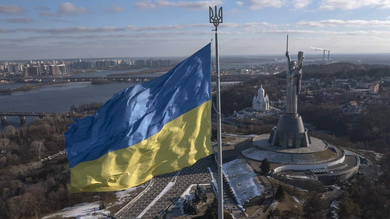 A view of Ukraine's national flag waves above the capital with the Motherland Monument on the right, in Kyiv Sunday, Feb. 13, 2022.